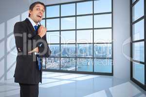 Composite image of thinking businessman holding pen