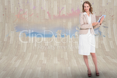 Composite image of happy pretty businesswoman holding a tablet p