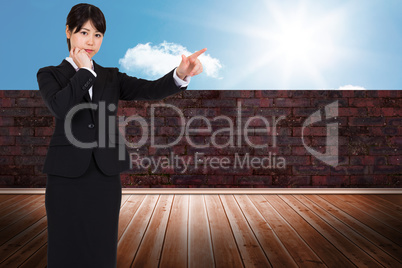 Composite image of thoughtful businesswoman pointing