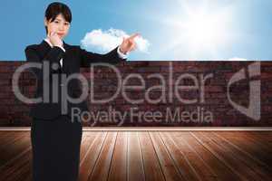 Composite image of thoughtful businesswoman pointing