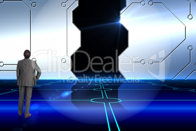 Composite image of businessman with hand on hip