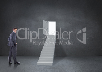 Composite image of serious businessman with hands on hips