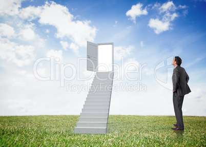 Composite image of smiling businessman with hands on hips