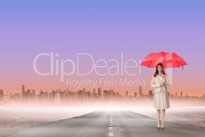 Composite image of attractive businesswoman holding red umbrella