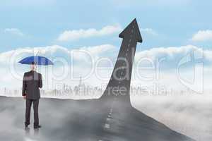 Composite image of businessman holding umbrella