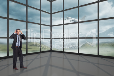 Composite image of stressed businessman with hands on head