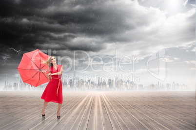 Composite image of elegant blonde holding umbrella