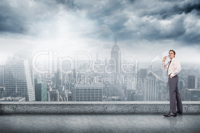 Composite image of thinking businessman holding glasses