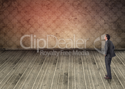 Composite image of smiling businessman with hands on hips