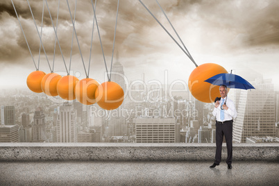 Composite image of happy businessman holding umbrella