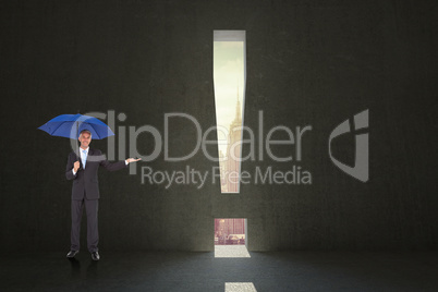 Composite image of peaceful businessman holding blue umbrella