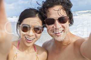 asian couple at beach taking selfie photograph
