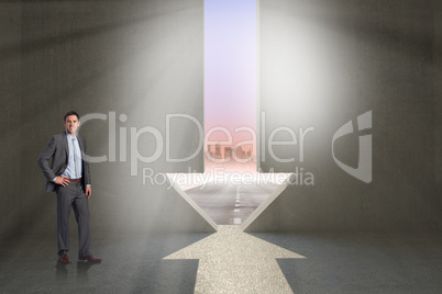 Composite image of smiling businessman with hand on hip