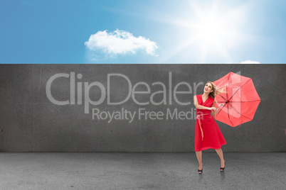 Composite image of elegant blonde holding umbrella