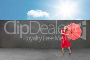 Composite image of elegant blonde holding umbrella