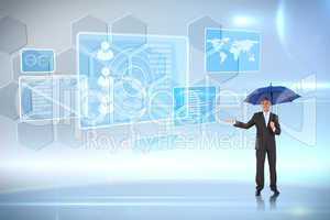 Composite image of peaceful businessman holding blue umbrella