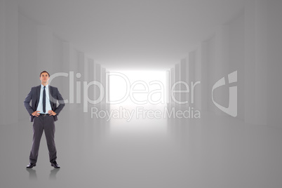 Composite image of serious businessman with hands on hips Composite image of serious businessman with hands on hips
