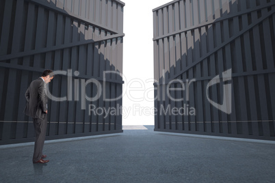 Composite image of businessman with hands on hips