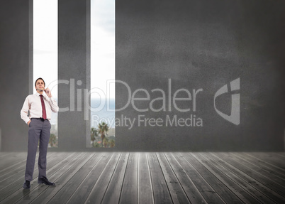 Composite image of thinking businessman holding glasses