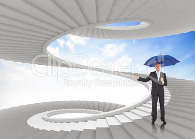 Composite image of peaceful businessman holding blue umbrella