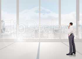 Composite image of thinking businessman holding glasses