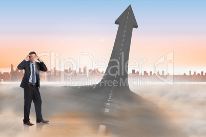 Composite image of stressed businessman with hands on head