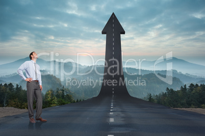 Composite image of smiling businessman with hand on hip