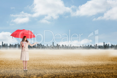 Composite image of attractive businesswoman holding red umbrella