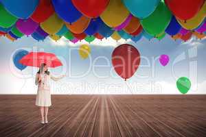 Composite image of attractive businesswoman holding red umbrella