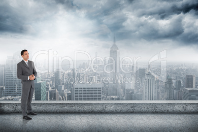 Composite image of businessman with hands folded