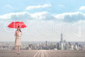 Composite image of attractive businesswoman holding red umbrella