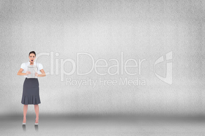 Composite image of shocked stylish businesswoman holding newspap