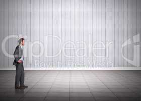 Composite image of smiling businessman with hands on hips