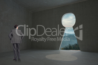 Composite image of businessman with hands on hips