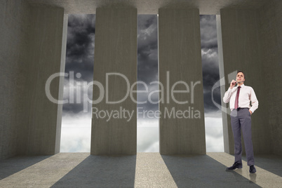 Composite image of thinking businessman holding glasses