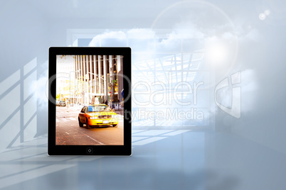 Composite image of yellow taxi on tablet screen