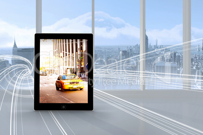 Composite image of yellow taxi on tablet screen