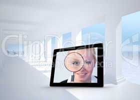 Composite image of businesswoman holding magnfying glass on tabl