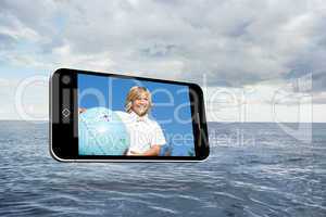 Composite image of blonde happy boy on smartphone screen