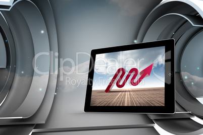 Composite image of red arrow on tablet screen