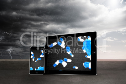 Composite image of falling pills on tablet and smartphone screen