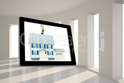 Composite image of house with price tag on tablet screen