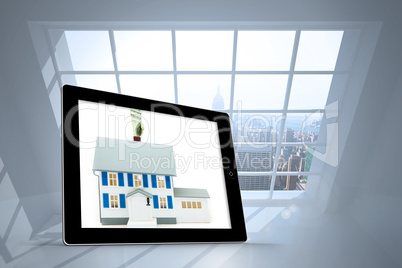 Composite image of house with price tag on tablet screen