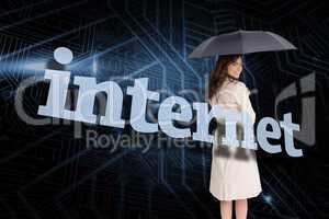 Businesswoman holding umbrella behind the word internet