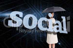Businesswoman holding umbrella behind the word social