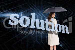 Businesswoman holding umbrella behind the word solution
