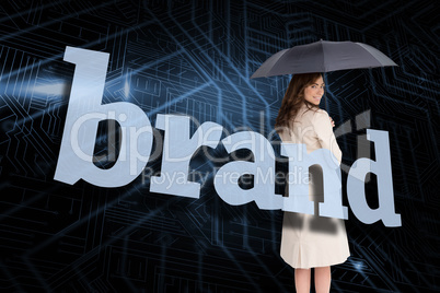 Businesswoman holding umbrella behind the word brand