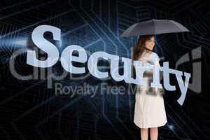 Businesswoman holding umbrella behind the word security