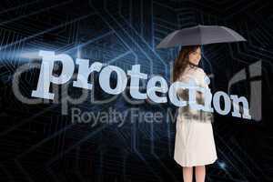Businesswoman holding umbrella behind the word protection