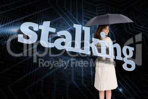 Businesswoman holding umbrella behind the word stalking